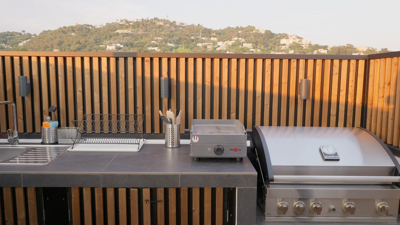 Aluwood aluminium slat cladding with vertical wood-finish slats over black backing on a rooftop kitchen facade
